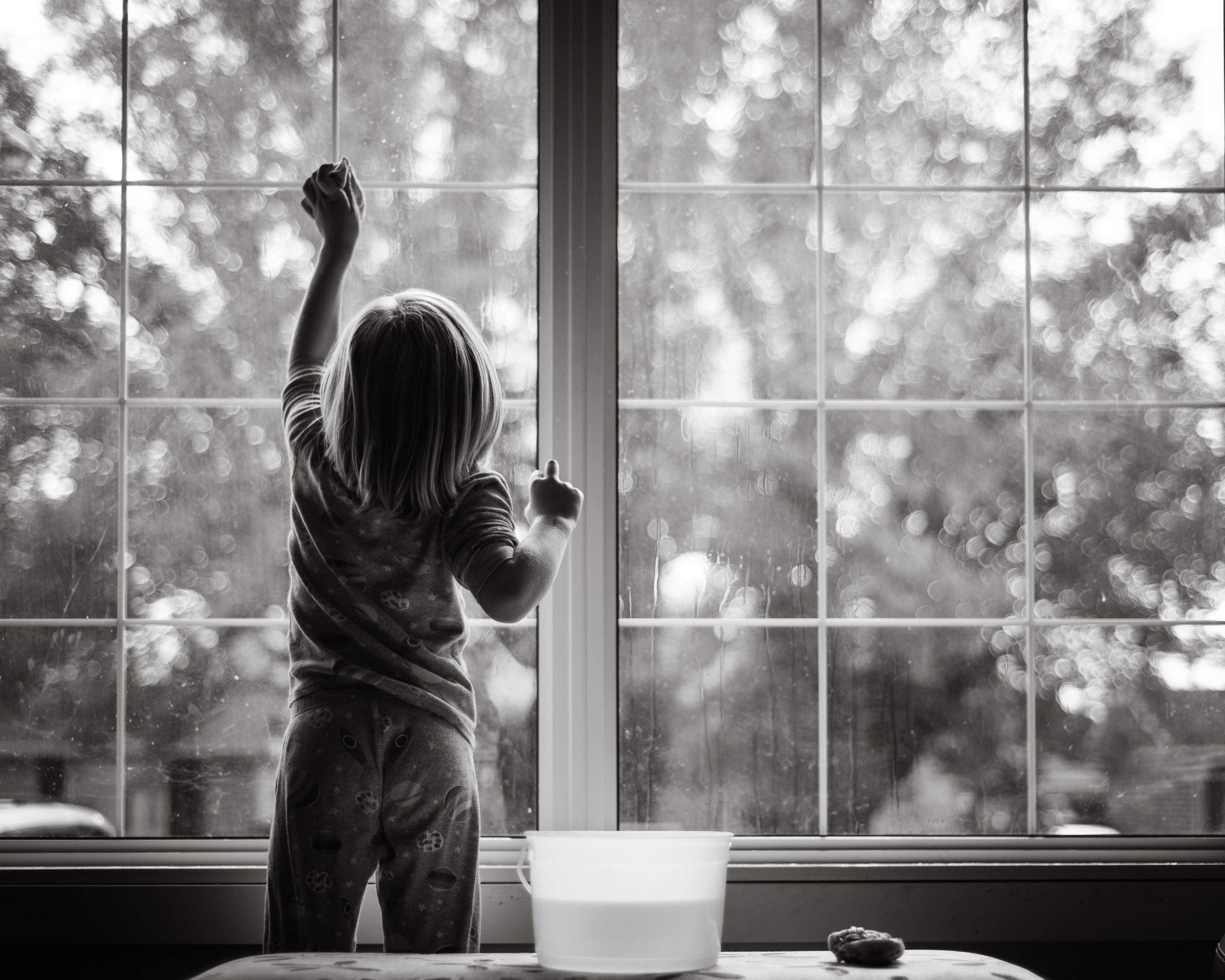 young girl cleaning windows to illustrate decluttering