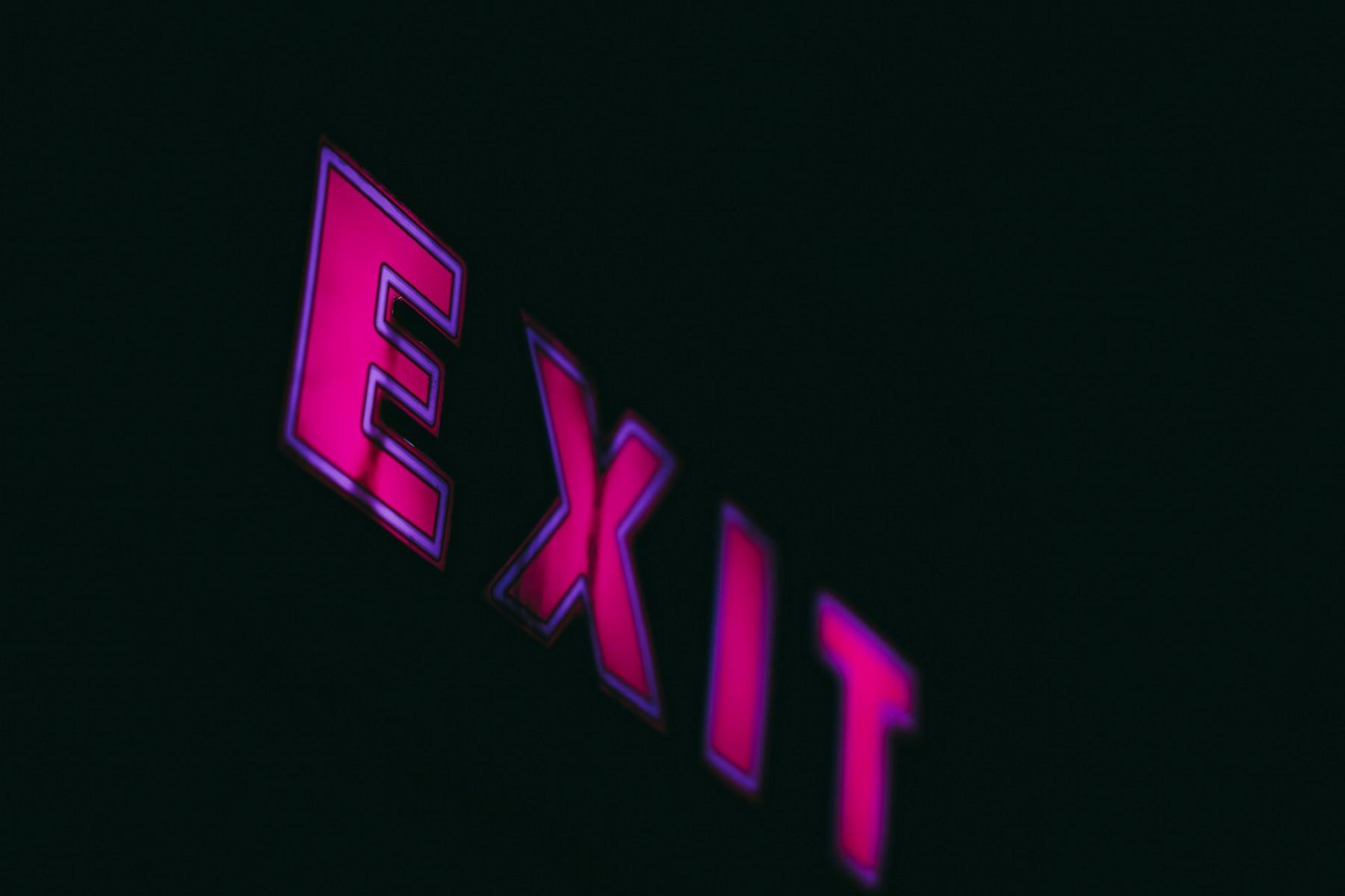 pink neon sign saying exit